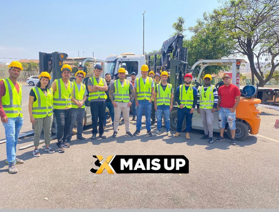 Turma de alunos da 3X MAIS UP com coletes e capacetes ao lado das empilhadeiras